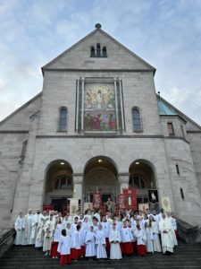 Schar von Ministranten und Pfarrern auf der Kirchentreppe